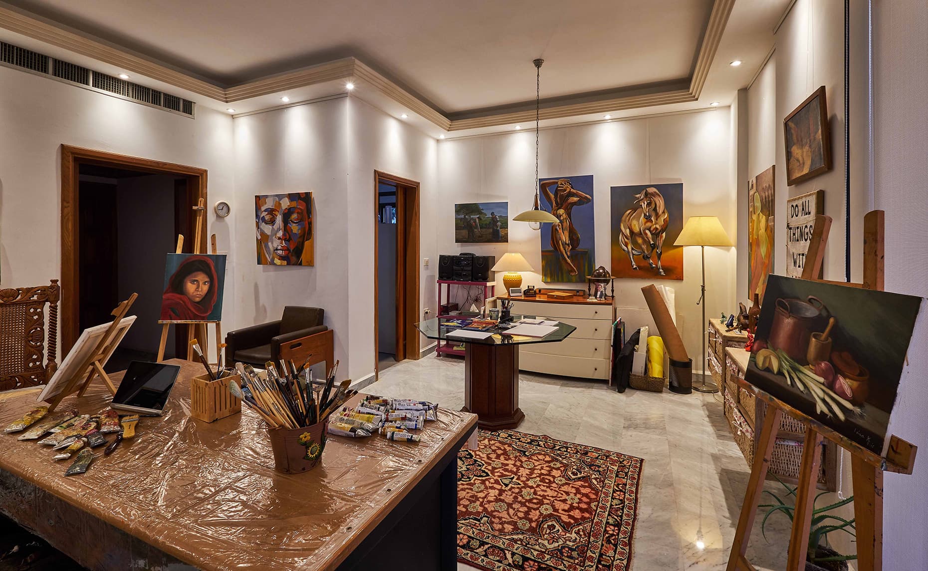 The atelier in Naccache, with paintings on the walls and brushes on the table